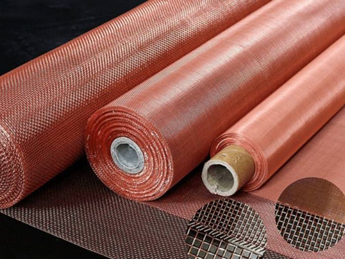 3 rolls of copper woven mesh laid flat on a black background