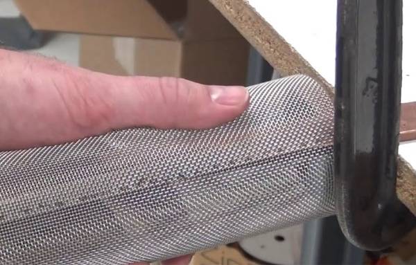 Worker is spot welding filter element.