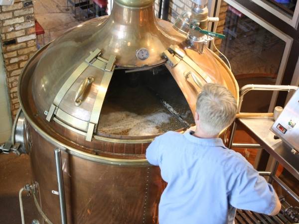 労働者はビールを醸造するための小麦をかき混ぜている。