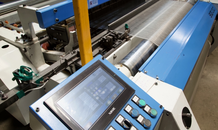The fully automatic weaving machine is weaving stainless steel wire cloth.