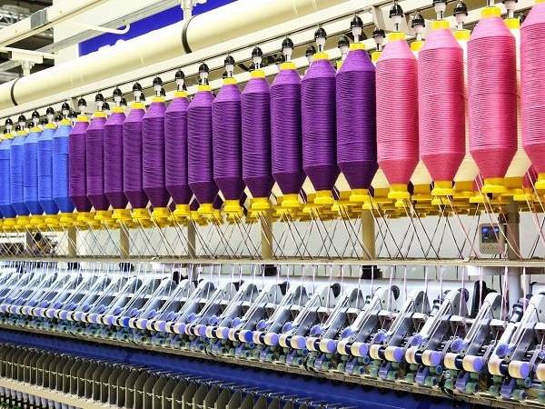 Colorful yarns are woven into textile in the machine.